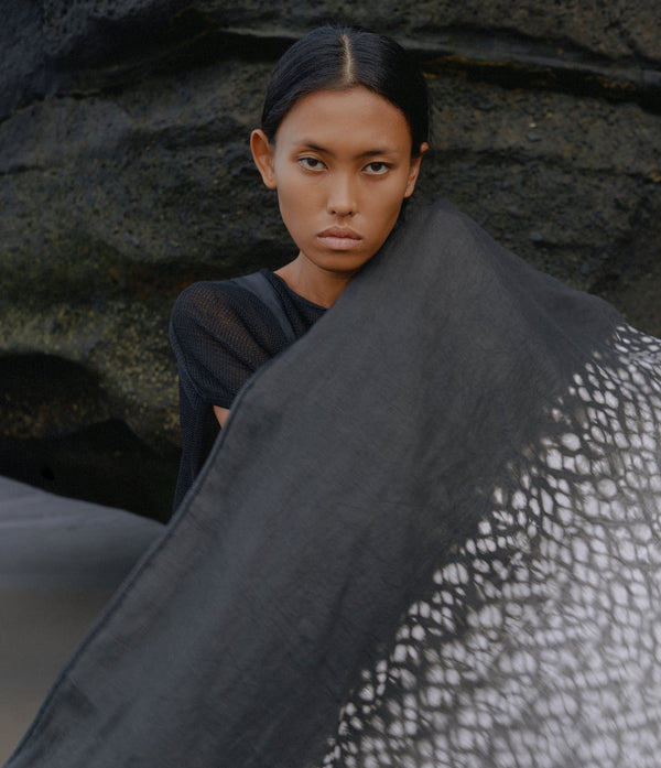 women standing in front of a black rock wearing a black and white tie dye linen scarf