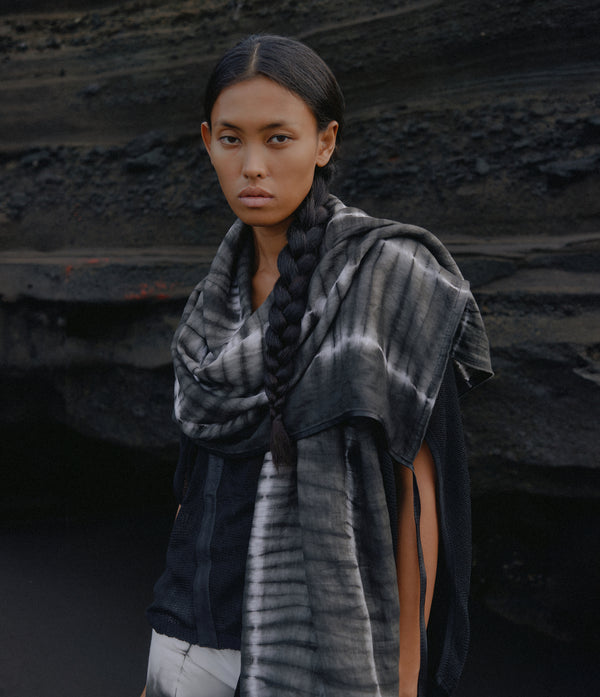 women standing in front of a black rock wearing a black and white tie dye linen scarf with leather tassels