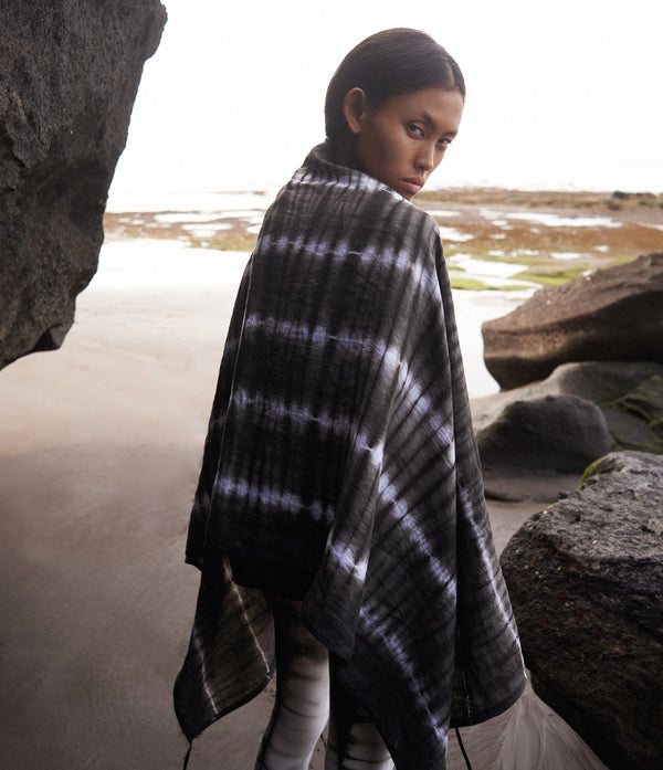 women standing on the beach wearing a black and white tie dye linen scarf with leather tassels