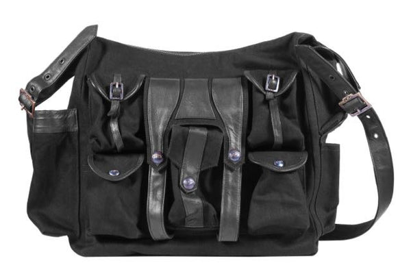 Canvas and leather shoulder travel bag with fabric lining and custom hardware.