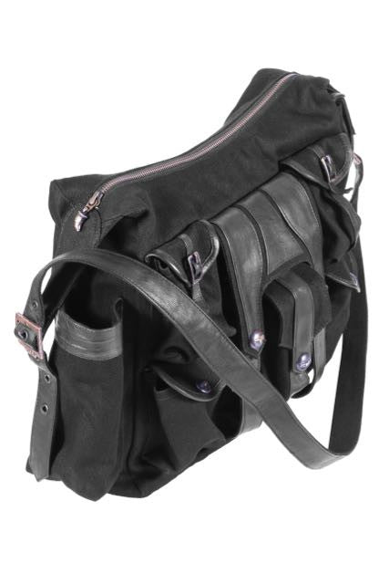 Canvas and leather shoulder travel bag with fabric lining and custom hardware.
