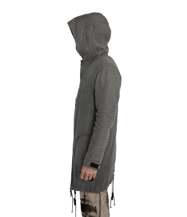 Unisex parka made of light weight linen. Featuring large lined hood, hidden snaps over front zip fastening, long sleeves with ribbed detail, snaps on cuffs, a drawstring waist, front frayed edge pockets, leather detail on cuffs, collar and back, leather tassel zip on outside chest pocket, earphone loop on inside chest pocket, a drawstring hem and a mid-length.